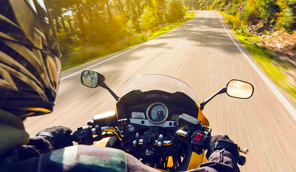 person riding motorcycle and protecting their hearing