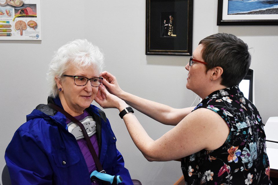 Hearing specialist assisting an older adult with a hearing aid fitting at Bradford HearingLife Centre.