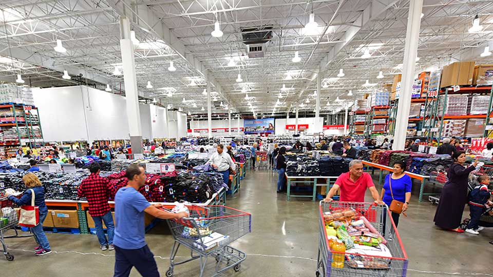 Shopping in a busy supermarket aisle filled with groceries and clothing displays.
