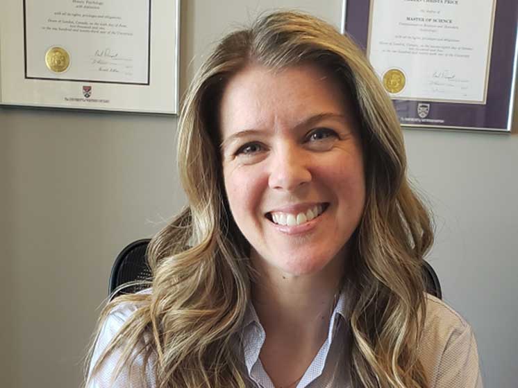 HearingLife audiologist seated in an office with framed certifications on the wall