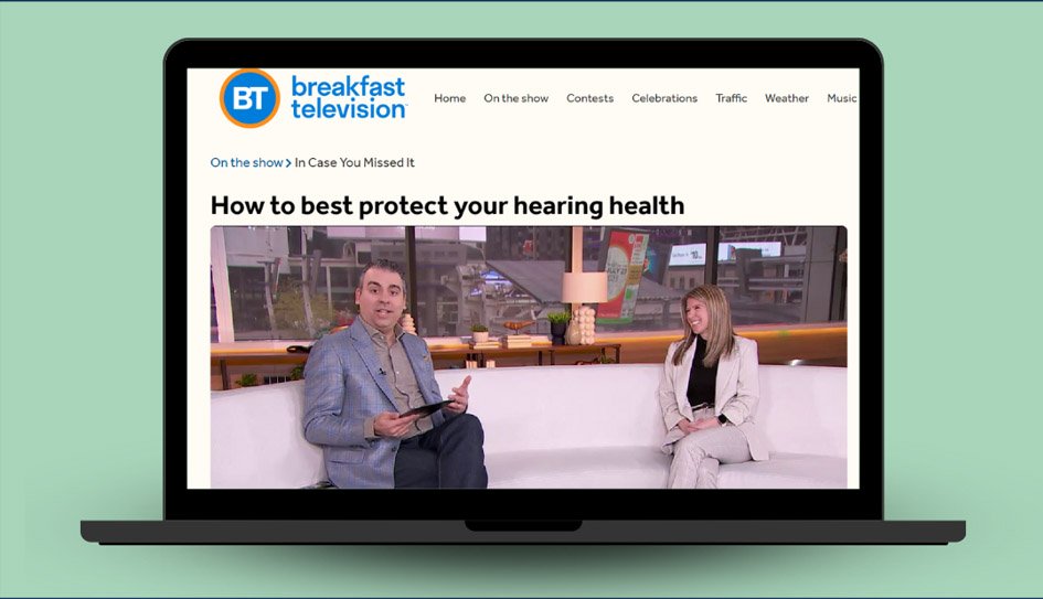 A laptop screen displays a segment from Breakfast Television titled ’How to best protect your hearing health.’ The page highlights two blurred individuals seated on a studio set, discussing hearing care in a casual talk-show format.