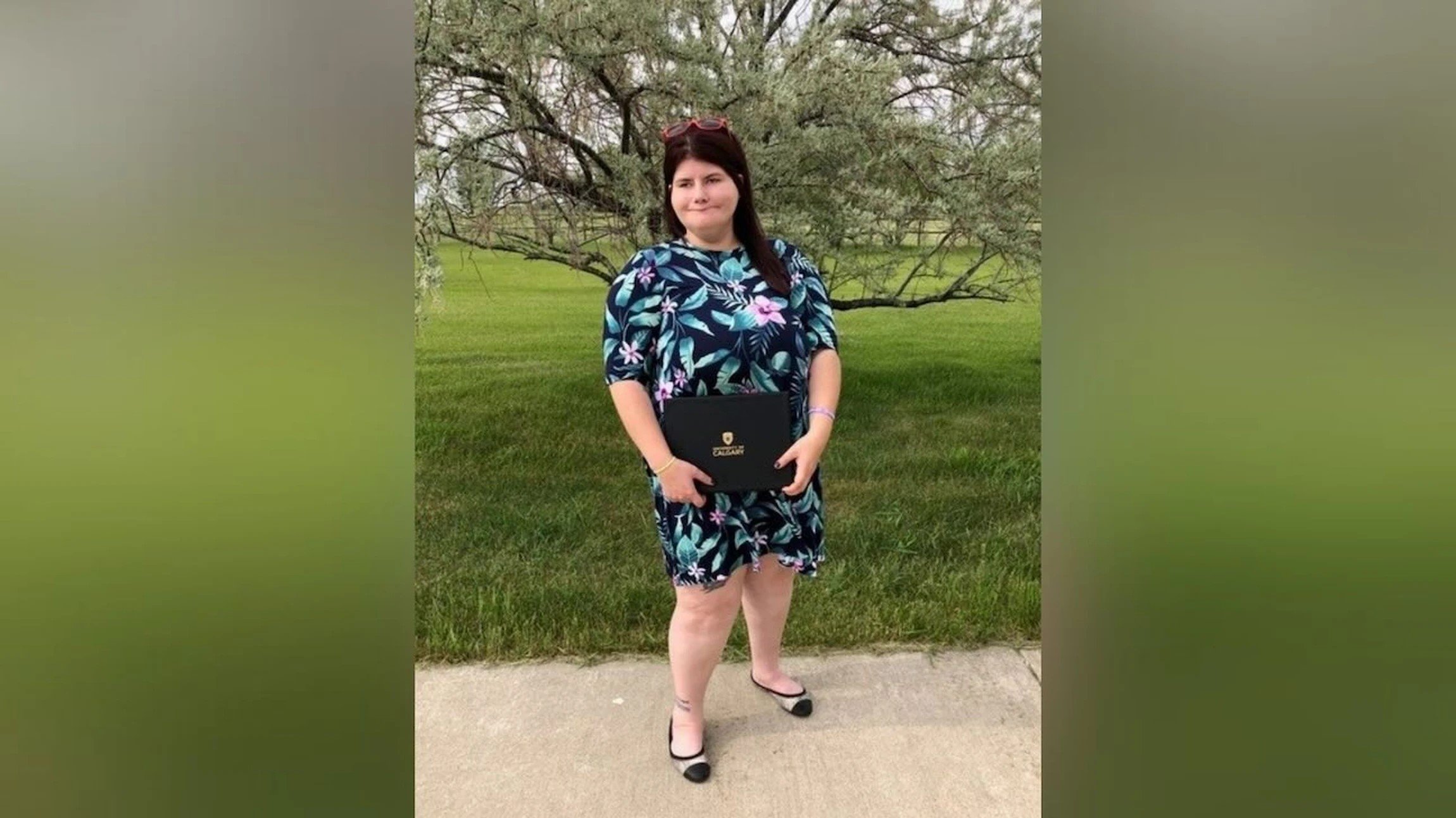 Campaign for Better Hearing recipient Kelsey Ferrill standing outdoors holding an award folder.