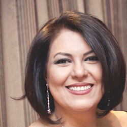 Sima Yaghoobi with shoulder-length dark hair in a professional setting.