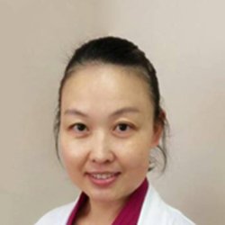 Hearing care professional Huiyan Lucy Wang in a white coat.