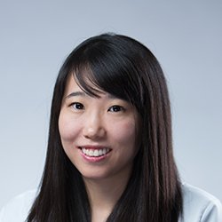Irene Chung, hearing care professional with long dark hair against a gray background.