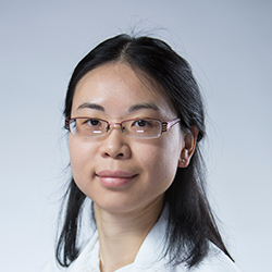 A person with long dark hair is shown wearing a discreet hearing aid in their right ear, positioned against a neutral gray background, highlighting hearing care solutions from HearingLife.