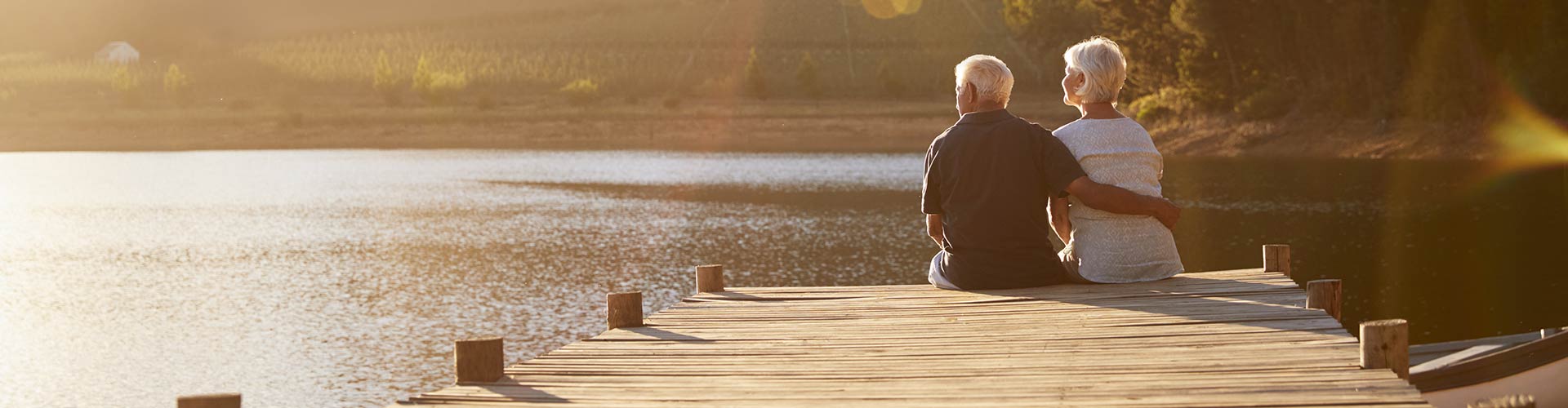 Image show couple sitting by the water in sunshine