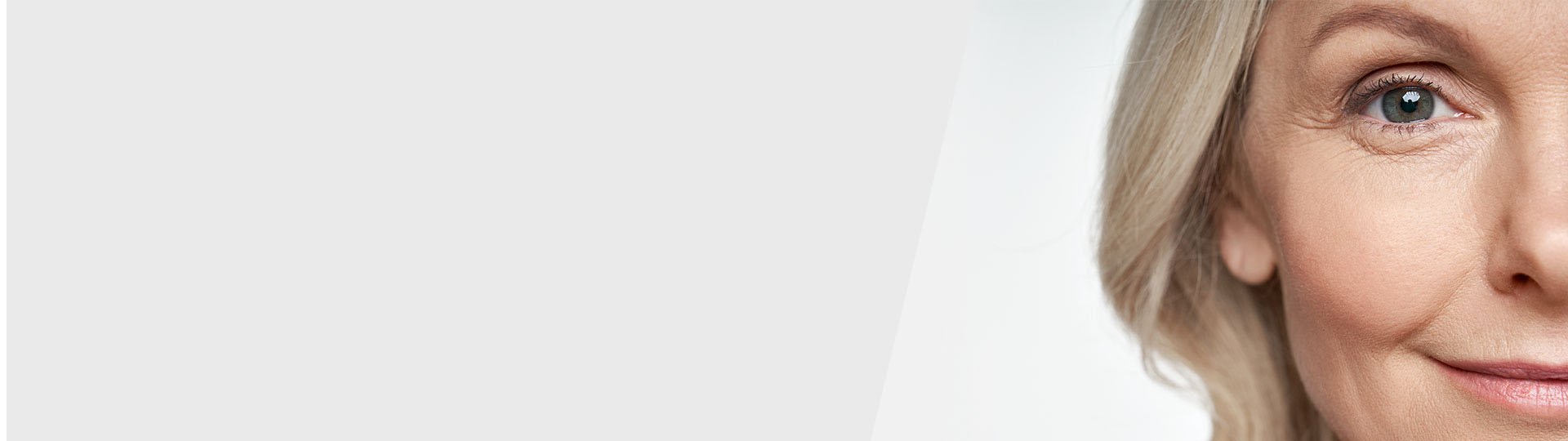 A close-up of a partial face featuring blonde hair on a neutral gray background, likely representing a professional or promotional context, possibly for a hearing clinic like HearingLife. No text is present.