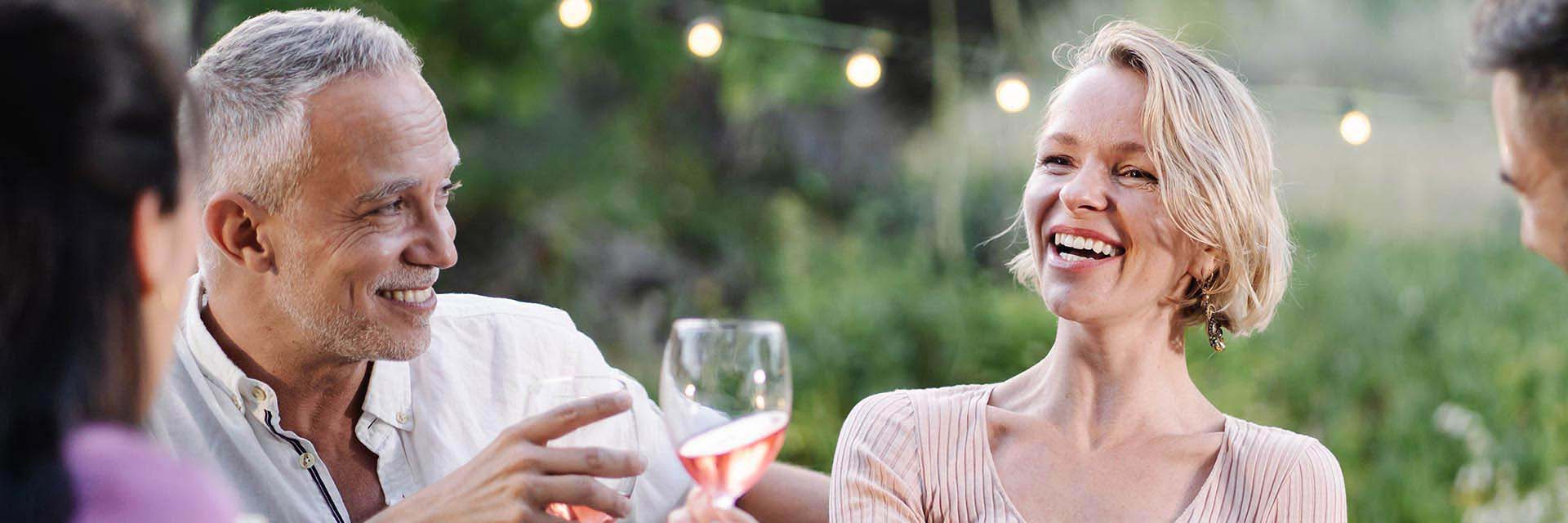 Happy man enjoying dinner with friends outdoors.