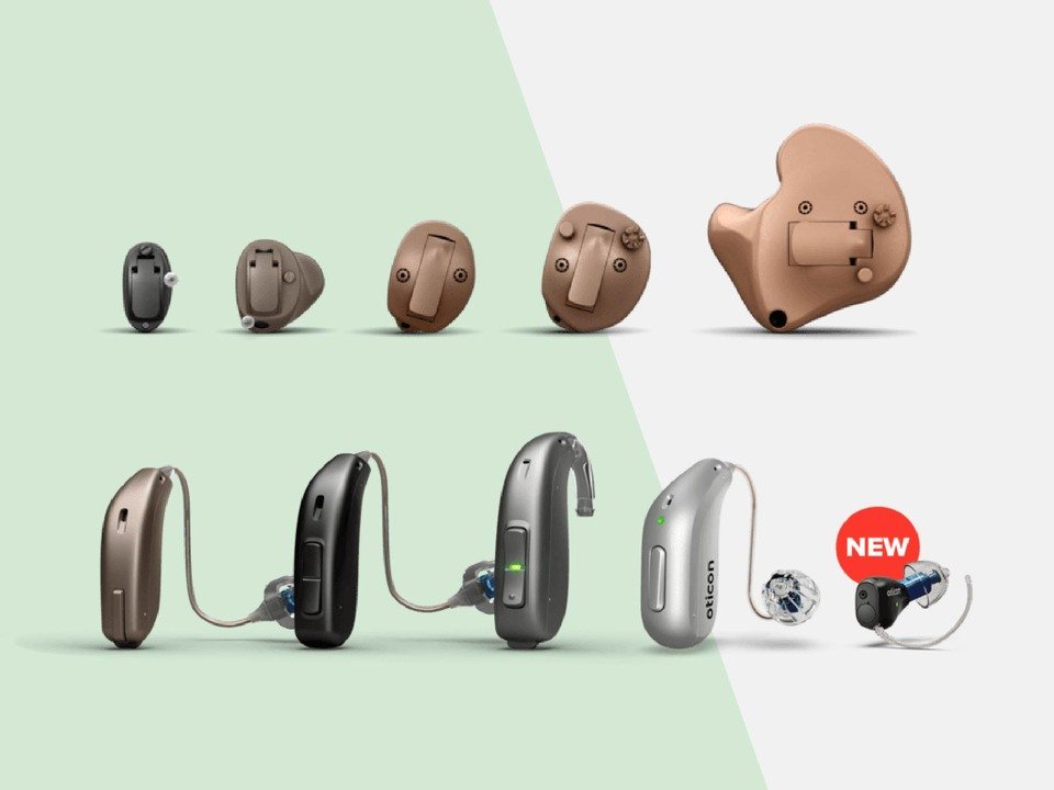 Various hearing aids are displayed, including in-the-ear and behind-the-ear models. The newest design marked ’NEW’ in a red circle.