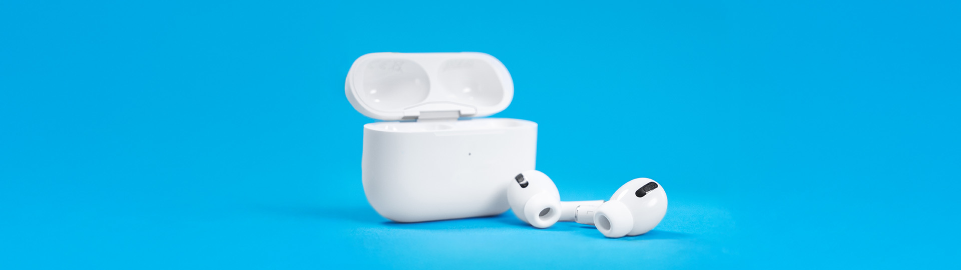 Apple AirPods® 2 with charging case on a vibrant blue background.