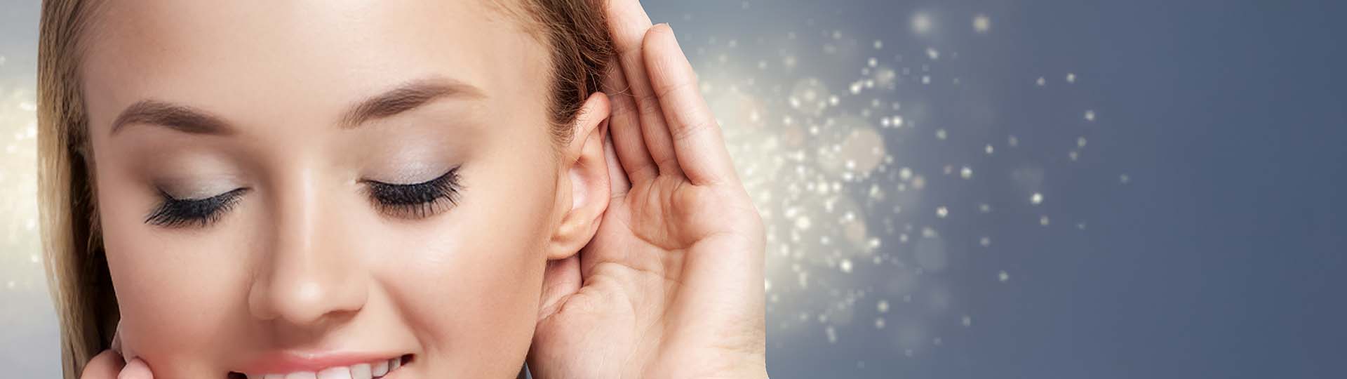 hand near ear with sparkling light representing sound entering