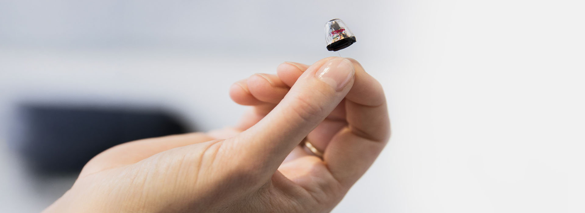 Hand holding a small hearing aid
