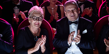 Couple clapping while seated in a theater audience
