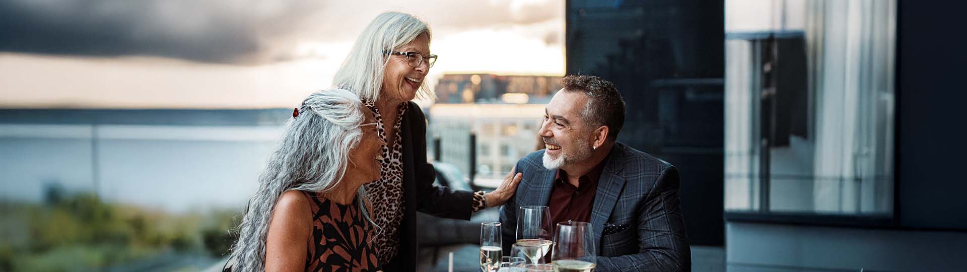 three people conversing easily and smiling