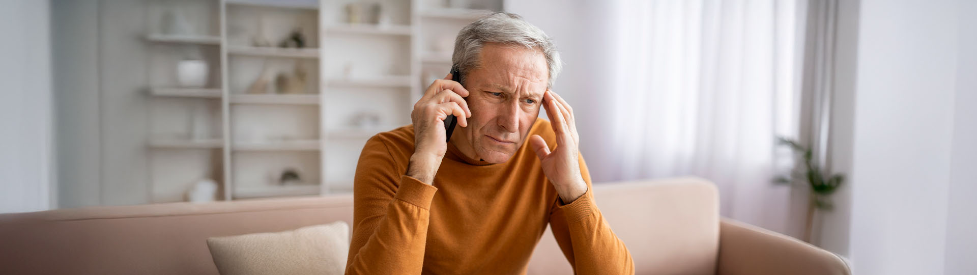 Man with tinnitus holding his ear