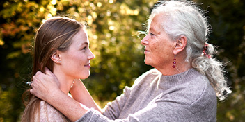Grandmother embracing her granddaughter outdoors