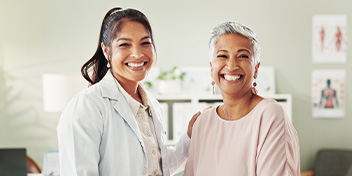 Smiling woman with her hearing care professional in a clinic setting.