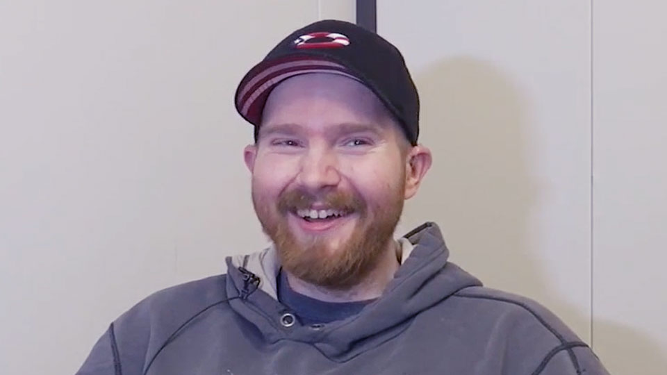albany resident with a cap smiles while benefiting from free hearing aids