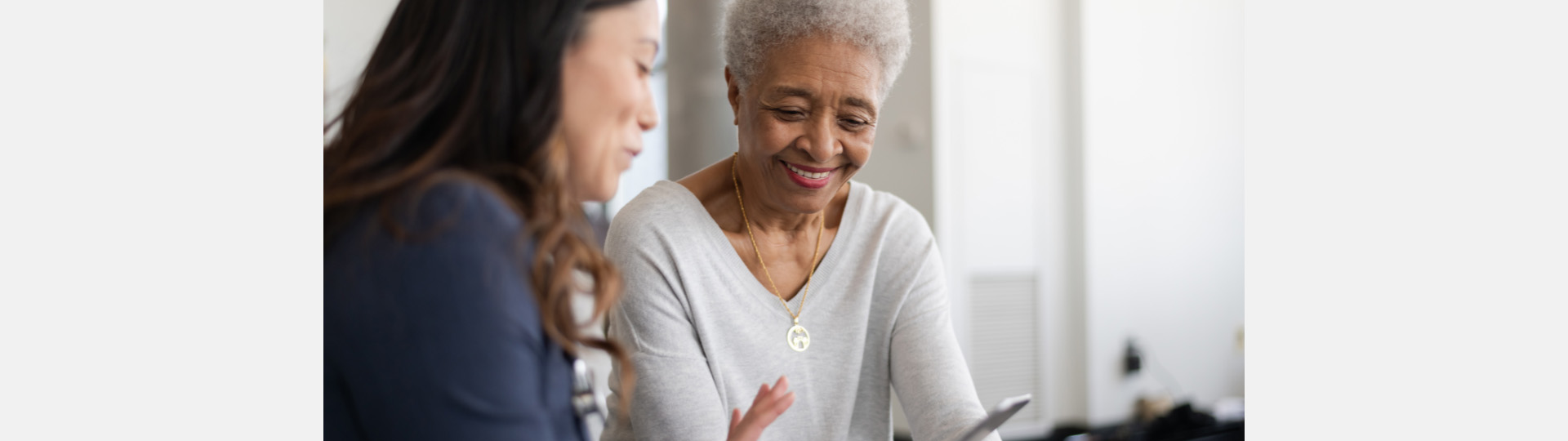Audiologist reviewing hearing test results with an older woman.