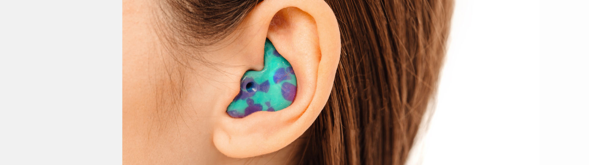 brightly colored custom earplug in the ear for hearing protection