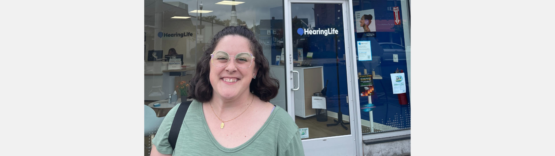Outside a HearingLife clinic with signage visible in the background.