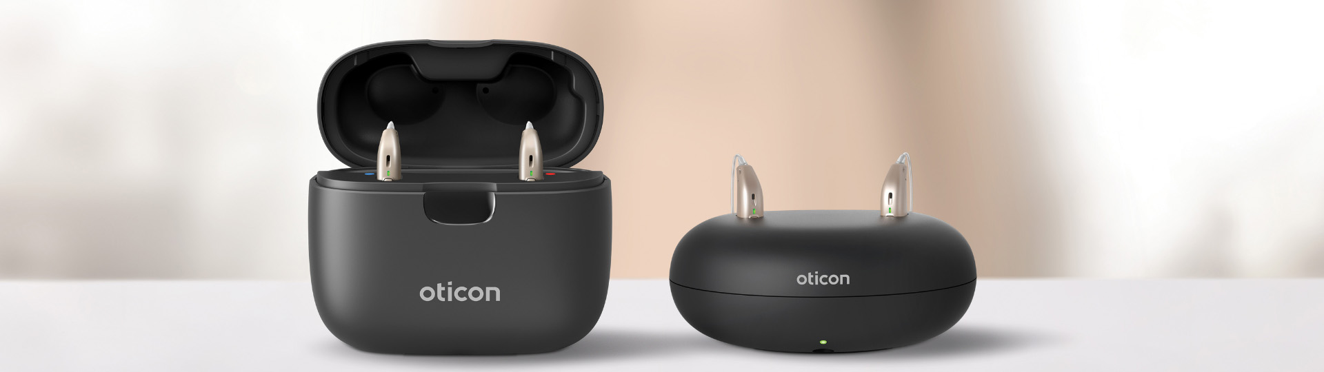 Oticon Real rechargeable hearing aids in sleek black charging cases.