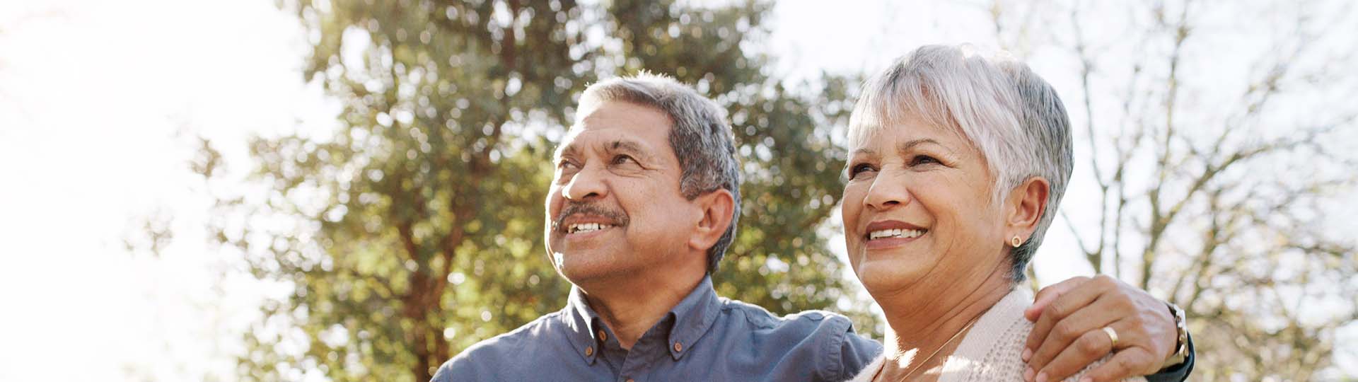 older couple embracing outdoors with a focus on hearing health awareness