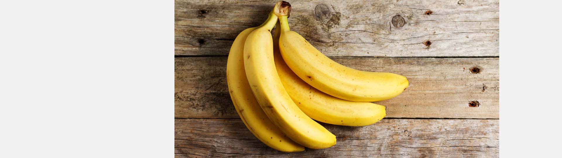 banana bunch resting on a rustic wooden table