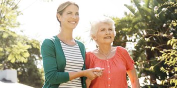 Caregiver and senior woman walking together
