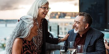 three people conversing easily and smiling