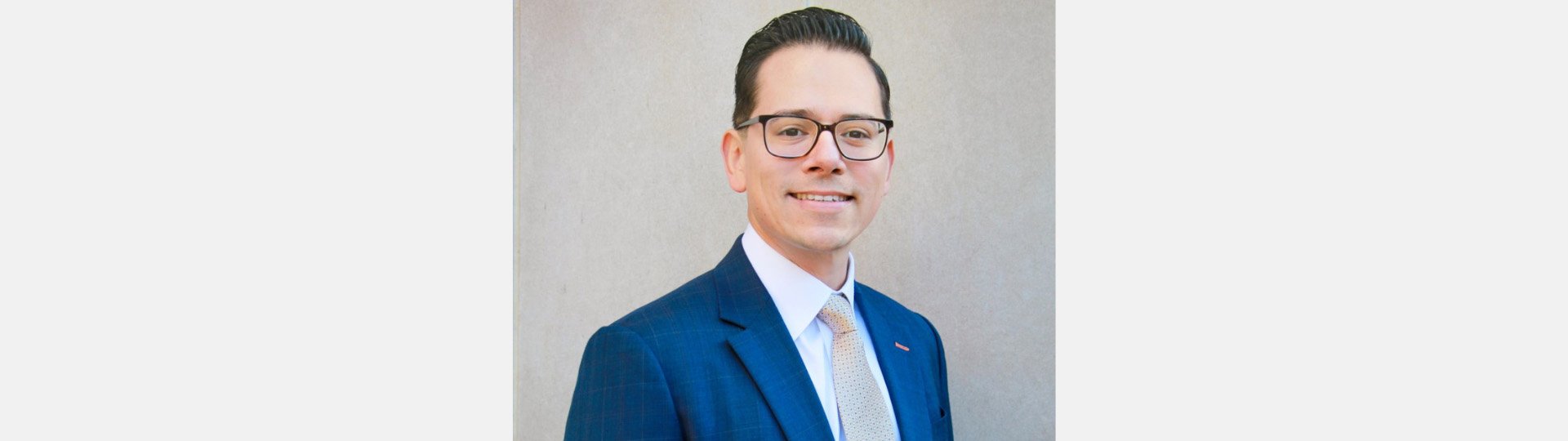 audiologist Filiberto wearing a blue suit with a white shirt and beige tie