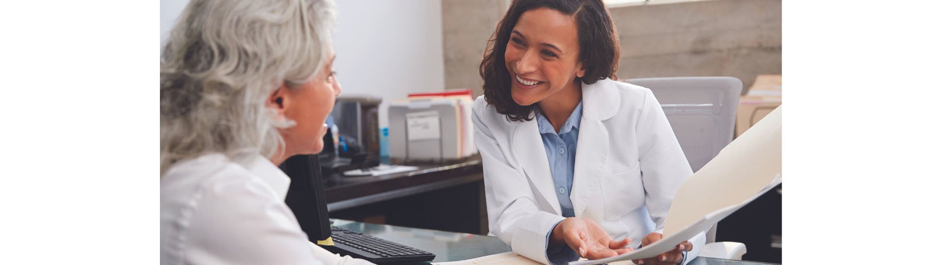 hearing specialist reviewing documents with a patient in an office setting