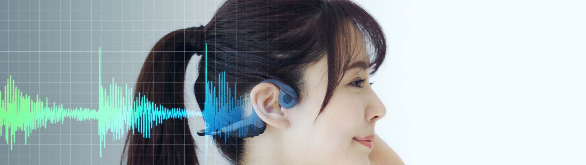 woman wearing bone conduction headphones with soundwaves visualized alongside her ear