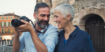 Couple smiling and enjoying photography while standing outdoors