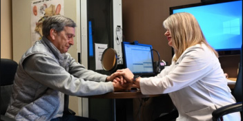 hearing care professional assisting a patient during a consultation in a clinic