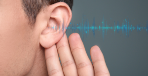 person holding hand up to ear and soundwaves