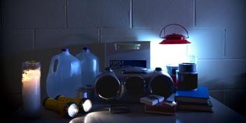 emergency supplies including flashlights, lantern, radio, candles, water containers, matches, books, and a first aid kit