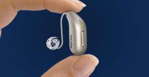 holding a NEW Oticon Intent™ hearing aid