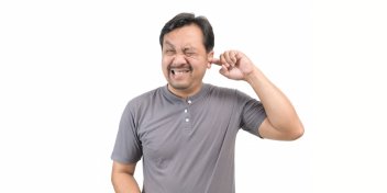 man scratching his ear due to itchiness