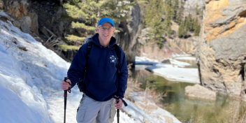 audiologist hiking a snowy trail alongside a river in Montana