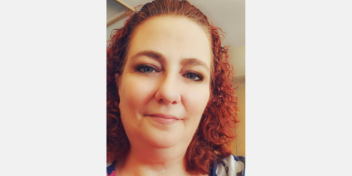 curly red-haired woman smiling warmly