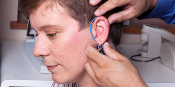 audiologist conducting real ear measurement on a patient