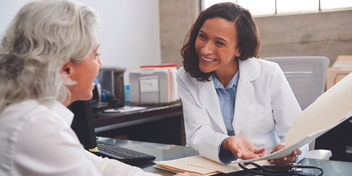 hearing care professional discussing test results and treatment options with a patient in a well-lit office
