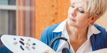 woman browsing different hearing aid options on a display