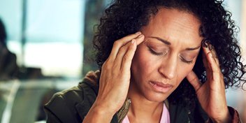 woman holding her ears, potentially experiencing tinnitus symptoms