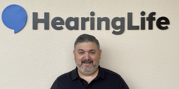 Tod Borges standing in front of a HearingLife sign