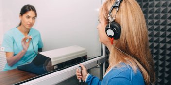 woman undergoing a professional hearing test in a sound booth