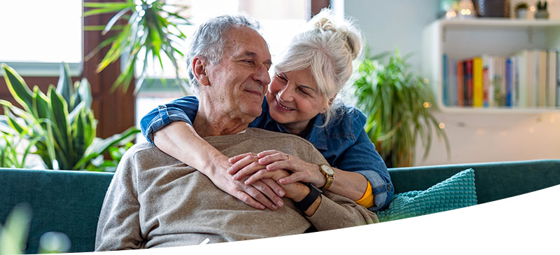 Couple hugging and smiling on a couch