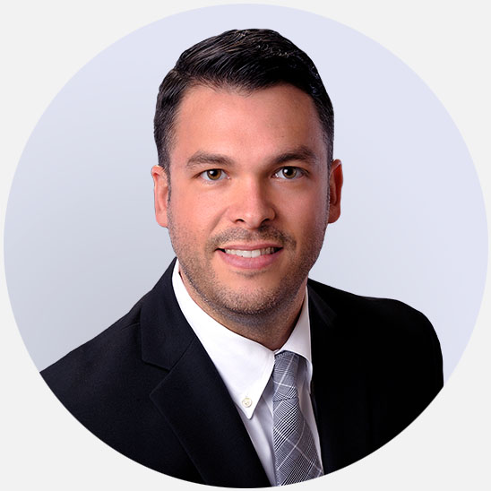 Ryan Potter, hearing care specialist in formal attire with a light green background.